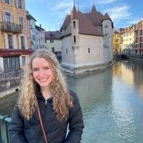 Student posing in front of river in France