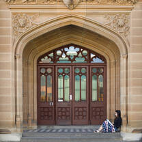 Student sitting outside against a building