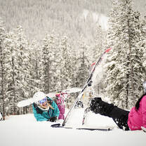 Snowboard girls lying in the snow
