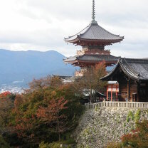 Japanese building on a hill with mountains behind