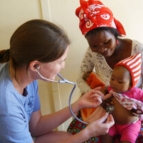 student doctor helping a mother and child 
