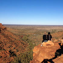 student sitting on a large red rock in Australia's Northern Territory
