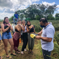 Students learning how to core and eat pineapple in Costa Rica