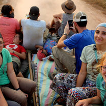 group of travellers riding in the back of a truck