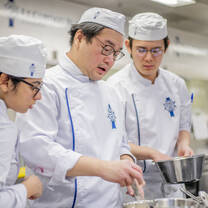 Students in the kitchen during Cuisine Diploma program at Le Cordon Bleu