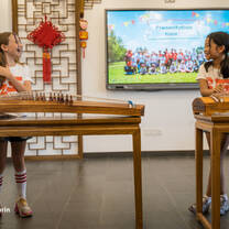 Campers laughing playing a Chinese instrument