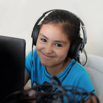 student with headset on at desk