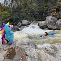 Student in unicorn costume watching whitewater kayakers