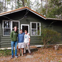 Roommates in front of their cabin