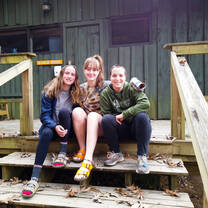 Roommates in front of their cabin