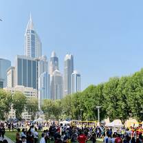 Students on the green AUD campus with the Dubai skyline in the background.