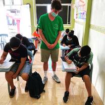 A Projects Abroad Teaching Volunteer helps Ecuadorian students with their work
