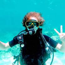 Woman doing peace symbol snorkeling under water