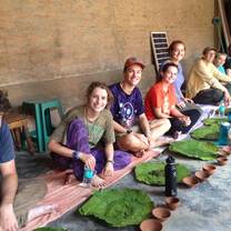 Students sitting down for a meal on banana leaves