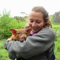 Female student holding a piglet