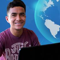 young male teacher at computer desk with virtual world behind
