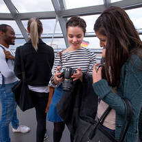 Two smiling students review photos on a camera