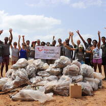Group together after beach clean-up with bags of trash