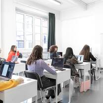 Students in a classroom sitting at white desks