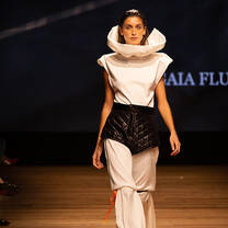 A model walking down the catwalk towards the camera displaying fashion student creations from Accademia del Lusso Milan