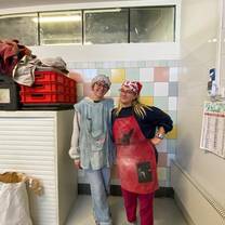 Two students standing together covered in flour from baking bread