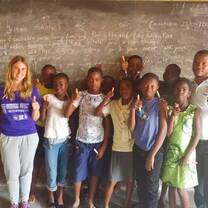 Volunteer and some students posing for picture after class