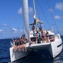 Group of teens sailing on a catamaran.