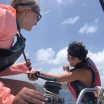 two teen girls sail a boat