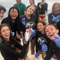 Group of teens on boat dissect fish
