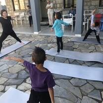 Grad volunteer teaching trauma recovery yoga to refugees