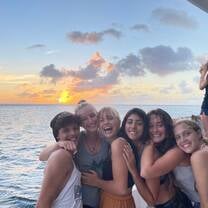 Group of teens on deck of boat at sunset