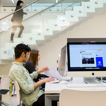 Two students sit at desktop computers