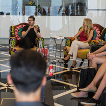 People seated in a modern-looking space with colorful chairs