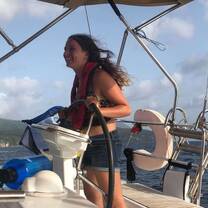 Teenage girl stands at the helm of a sailboat