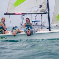 Four teens on small sailboat 