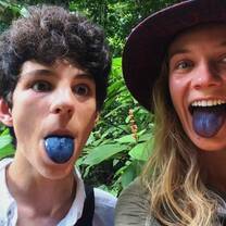 Two teens stick tongues out stained black