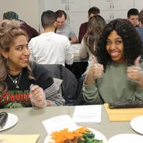 Students giving thumbs up trying sushi