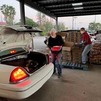 Volunteers loading food into families' cars