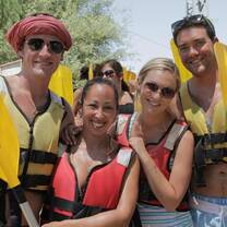 Four people in life vests smiling into the camera