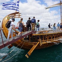 students getting on boat with greece flag