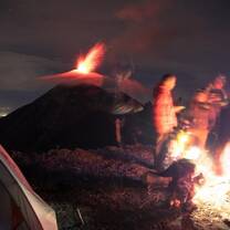 Witness volcanoes glowing in the dark from your tent