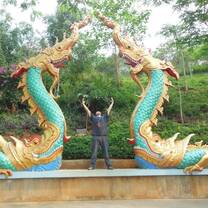 A student poses with two dragon statues.