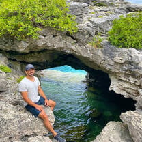 a man poses next to an underwater cave