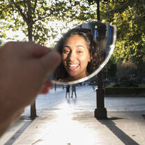 student poses in front of mirror on the street in prague