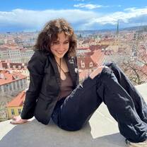 student poses in front of prague skyline