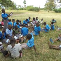 A girl child leading the rest of the children to read and concentrate on what took them to school.
