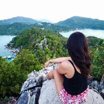 A teacher sits on a stone view point in Southern Thailand 