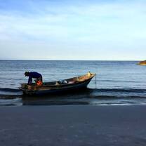 A picture of a long boat before sunset 