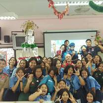 A teacher stands in a group photo with their Thai Highschool class