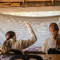 A Bushwise student raises her hand to ask a question during a lecture.